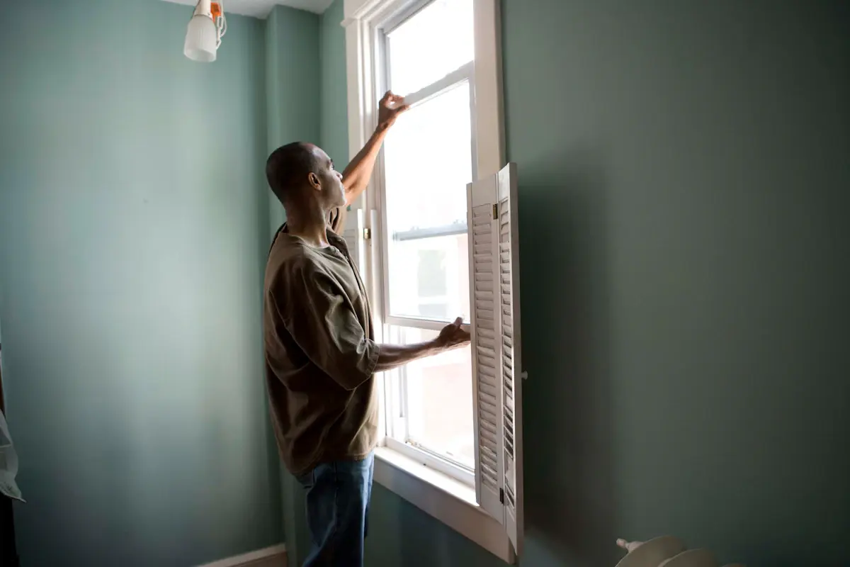 Contractor standing beside a newly installed window