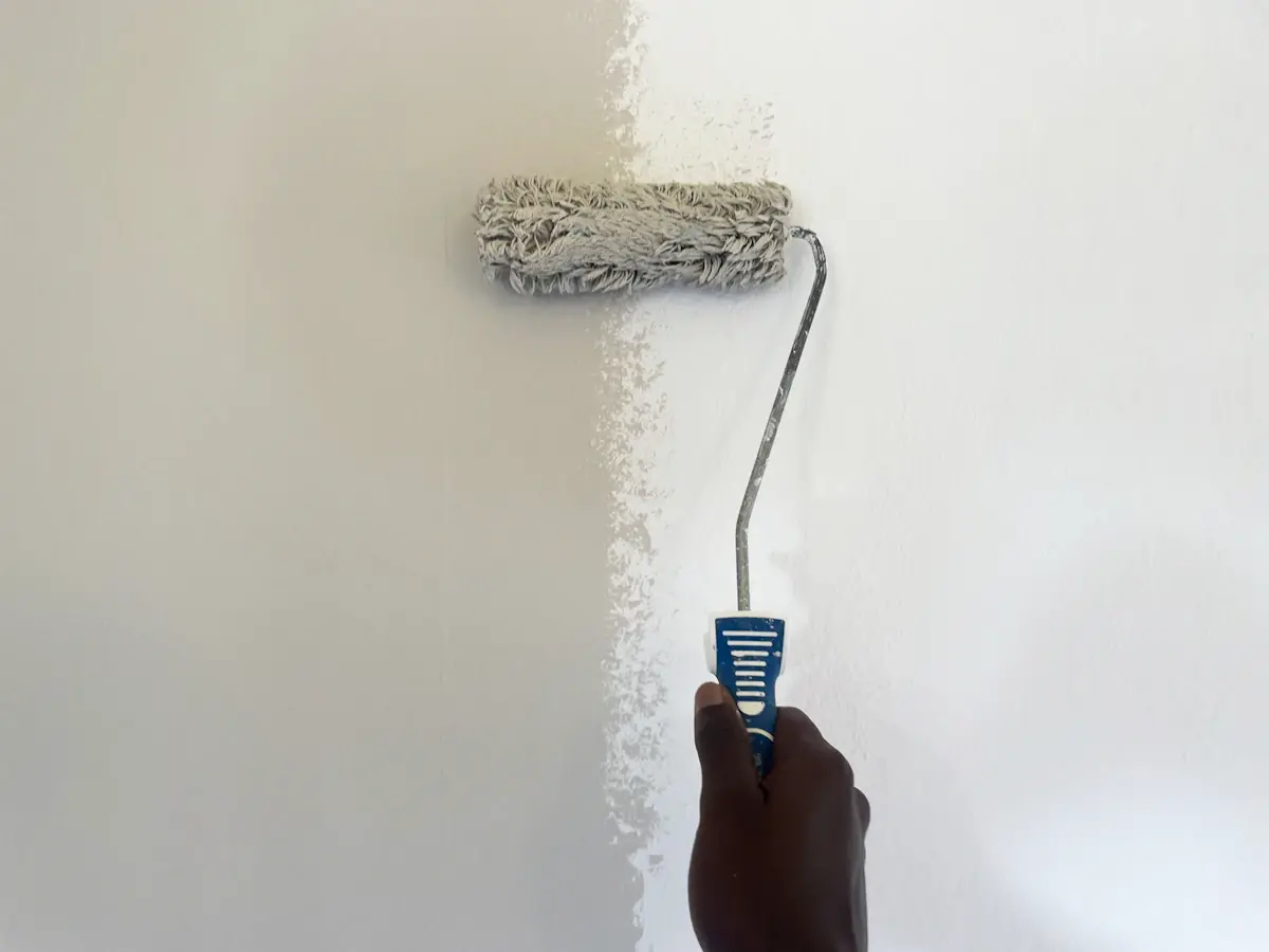 Painter applying paint with a roller in a residential space